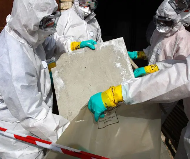 A group of people in hazmat suits holding up a piece of paper.