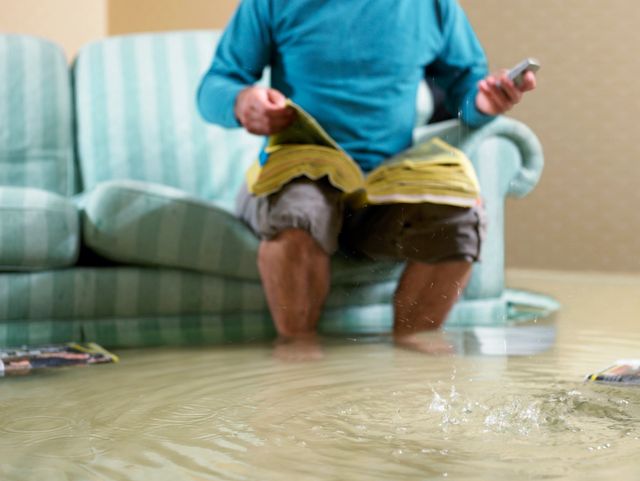 A man sitting on the floor in front of water.